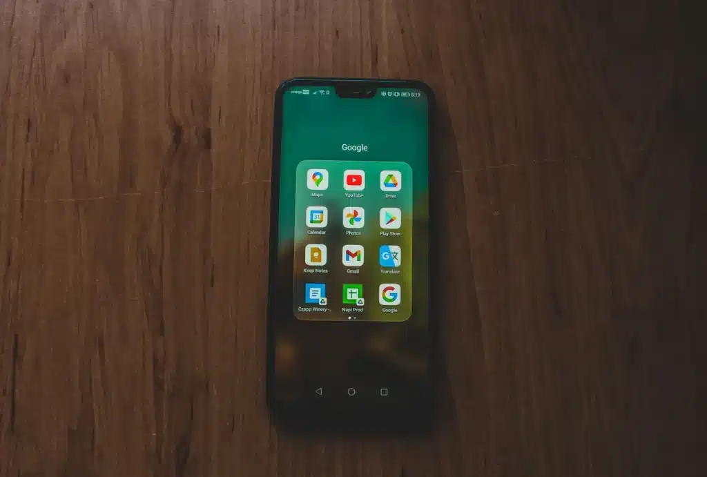 Main d'une personne tenant un smartphone affichant l'interface d'une application de streaming avec un bouton de lecture