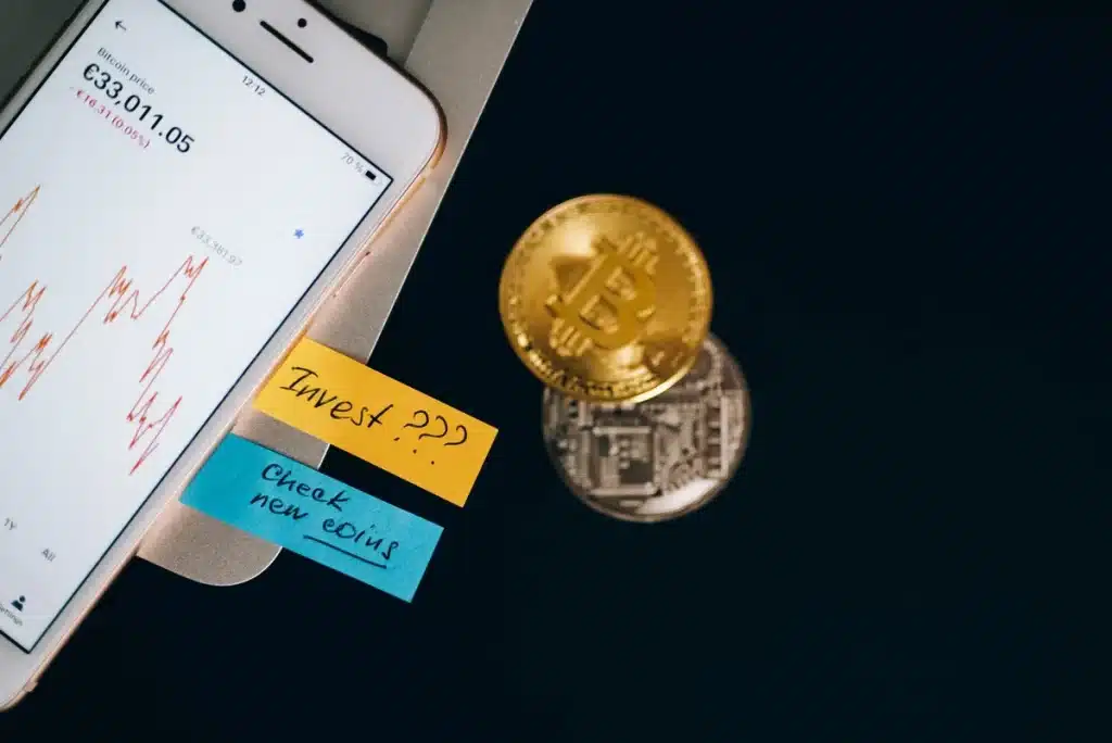 Bitcoin 100 000 $ en vue selon Standard Chartered: l’accélération des rachats du Trésor en cause Graphique montrant une courbe ascendante franchissant la barre des 100 000 dollars avec des symboles de crypto-monnaies.