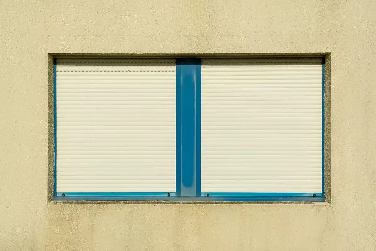 Fenêtre avec volets et rideaux fermés pour bloquer la chaleur du soleil