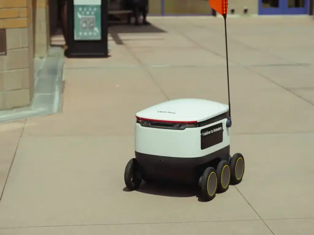 DoorDash ajuste Dot, son robot livreur : problèmes de charge et de collecte persistent Robot livreur autonome naviguant sur un trottoir urbain encombré