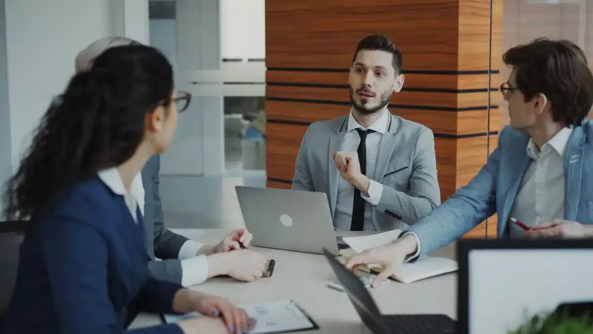 Des professionnels de la technologie en discussion autour d'une table, débattant de stratégie et d'innovation