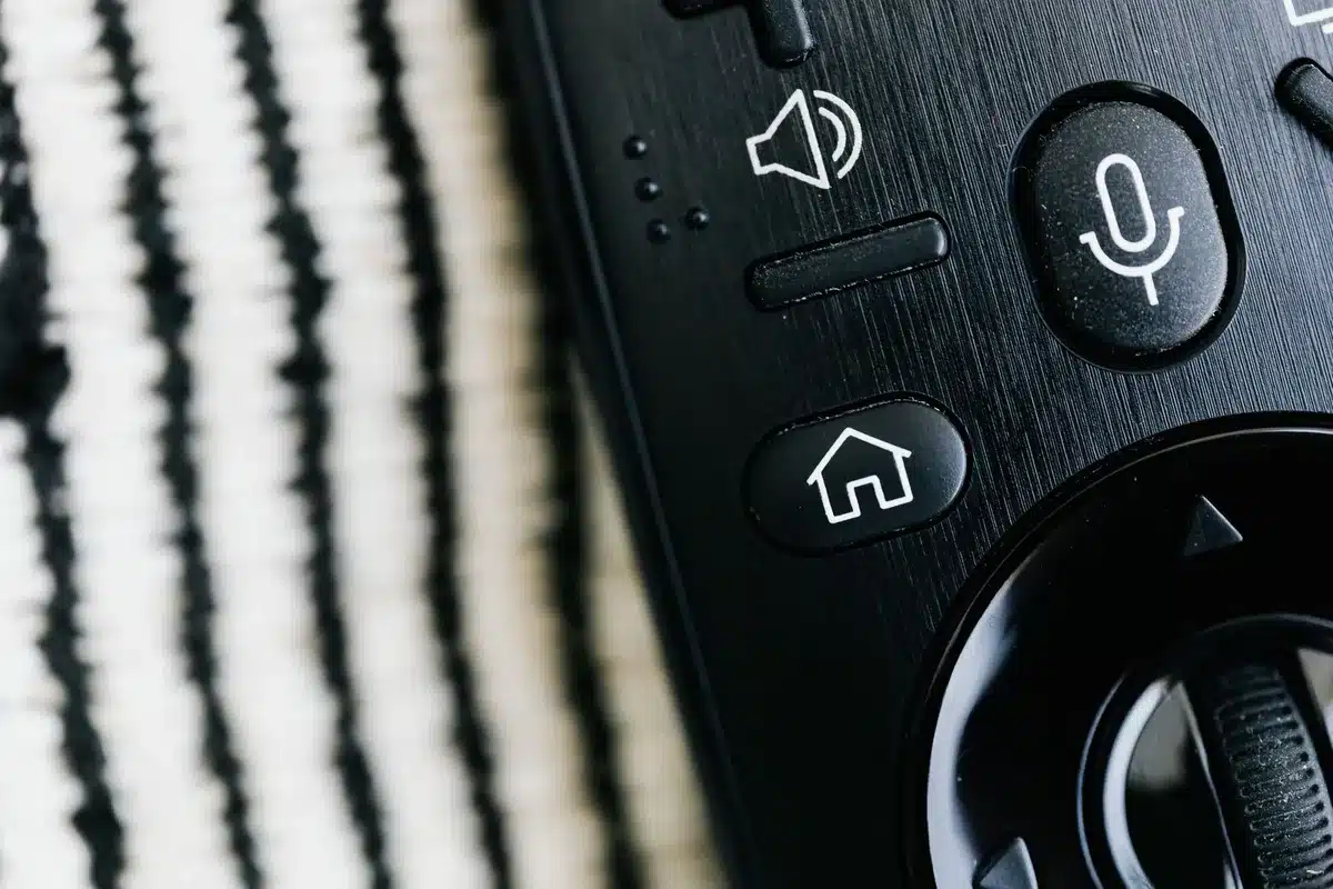 Gros plan sur une télécommande TV et des paramètres audio affichés à l'écran