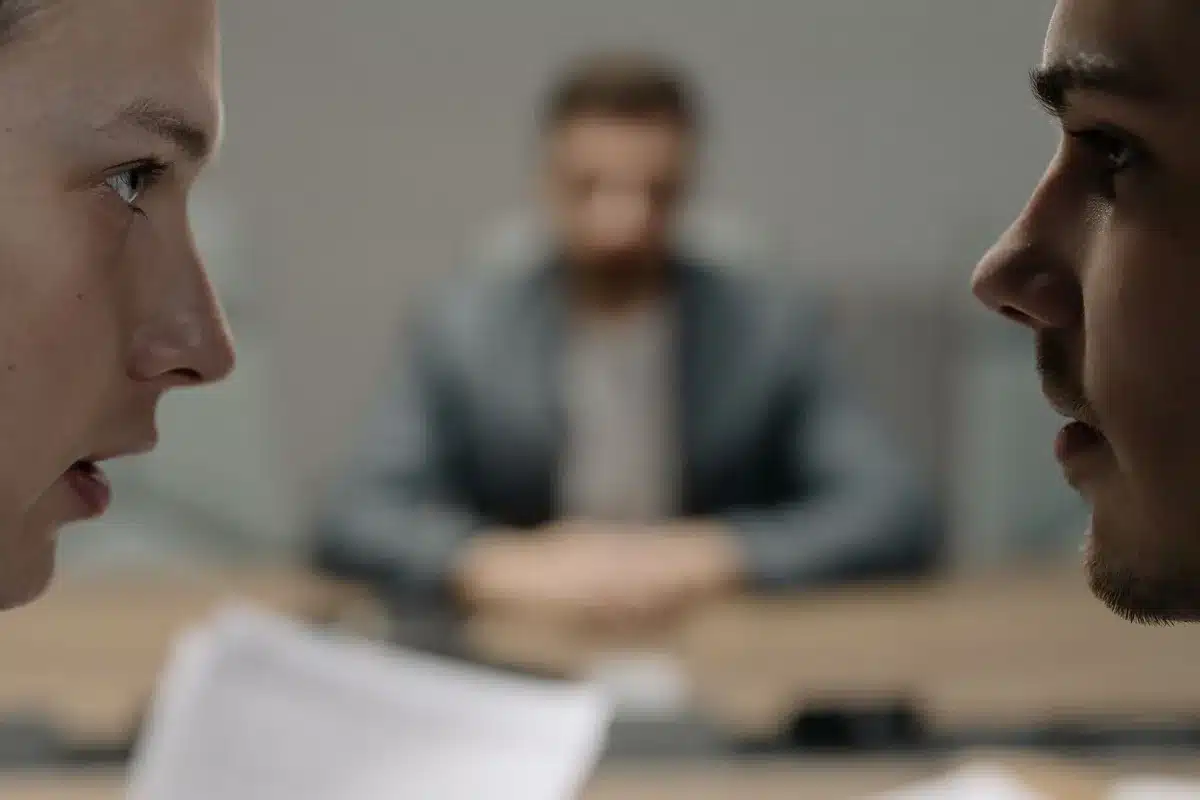 Deux hommes en interaction intense, illustrant la dynamique conflictuelle et complémentaire du duo