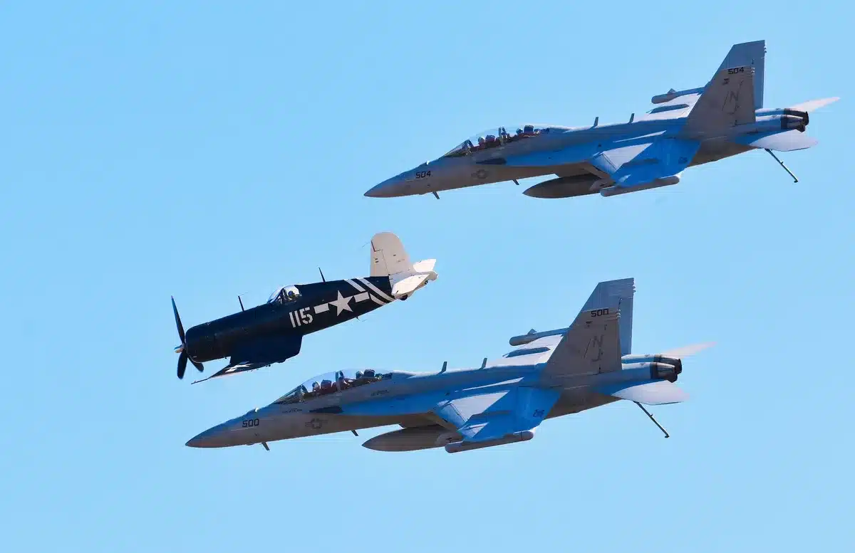 Deux avions de chasse en combat aérien rapproché avec traînées de fumée.