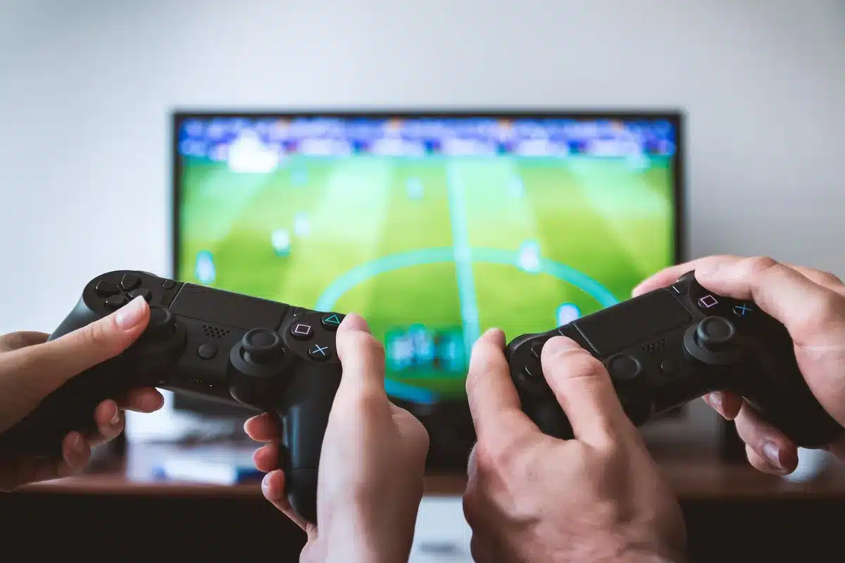 Deux joueurs coordonnant leurs actions dans un cockpit de jeu vidéo, l'un pilotant et l'autre tirant.