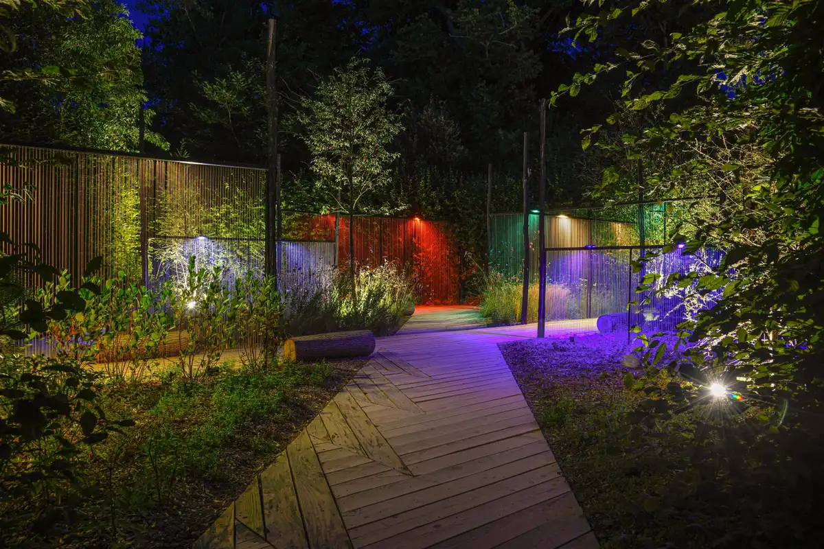 Projecteur LED blanc éclairant un chemin de jardin la nuit avec lumière variable