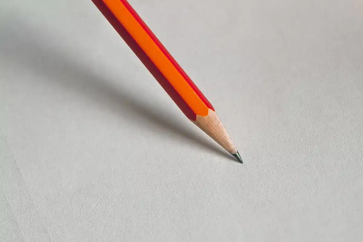 Main pointant vers des documents bancaires et calculatrice sur une table en plein jour
