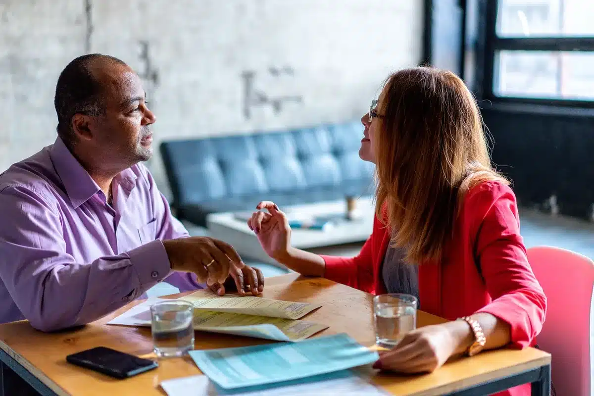 Deux collègues en conversation professionnelle dans un cadre de travail.
