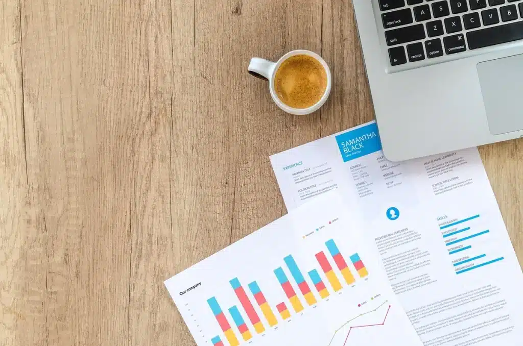 Crypto en reprise: le marché baissier s’achève, que faire maintenant Bureau en plein jour avec graphiques financiers et calculatrice, mains anonymes pointant un graphique