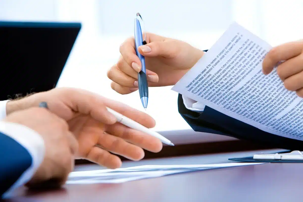 Documents réglementaires et formulaires de conformité empilés sur un bureau professionnel