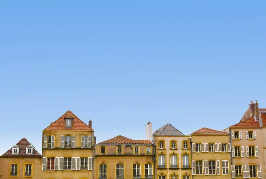 Place de village en plein jour avec une estrade décorative et des silhouettes anonymes