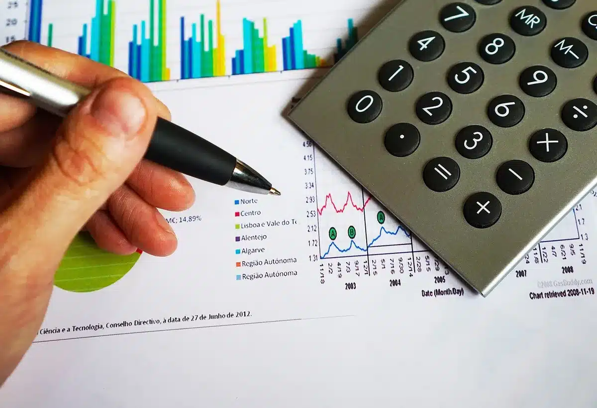 Documents de production, calculatrice et notes de budget sur un bureau