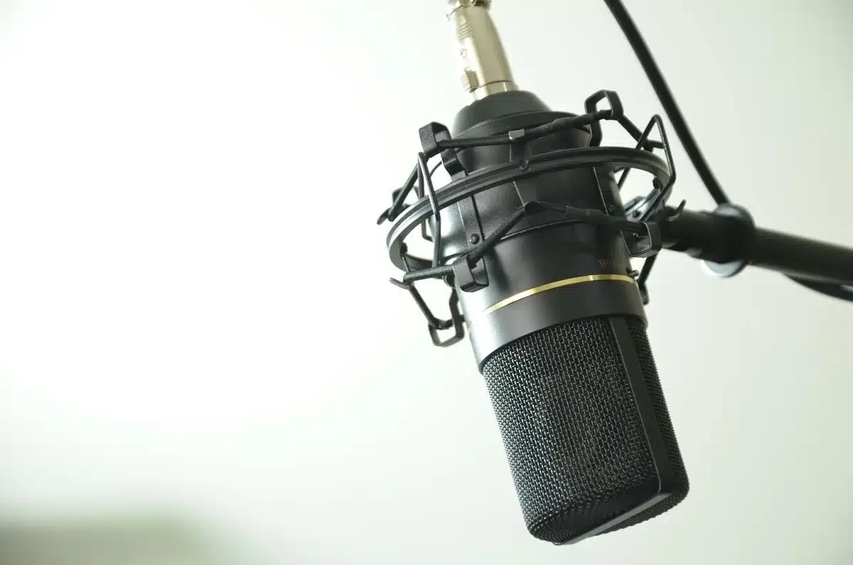 Equipement d'enregistrement de podcast posé sur un bureau sous une fenêtre en journée