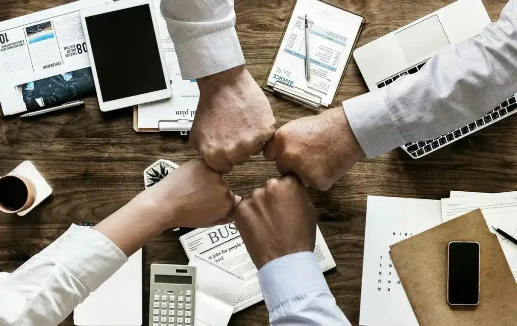 Bureau de trading en journée avec mains, carnet et calculatrice près d'une fenêtre