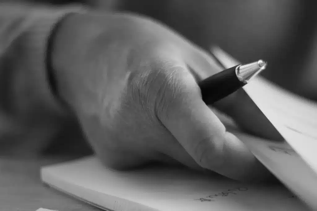 Bureau de studio de jeux en journée, papiers et mains anonymes sur une table