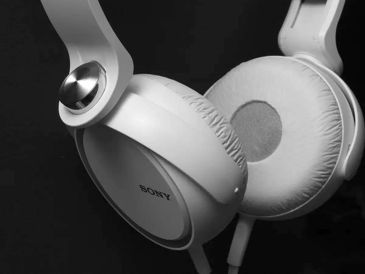 Casque sans fil posé à côté d'une housse souple et d'un billet de transport