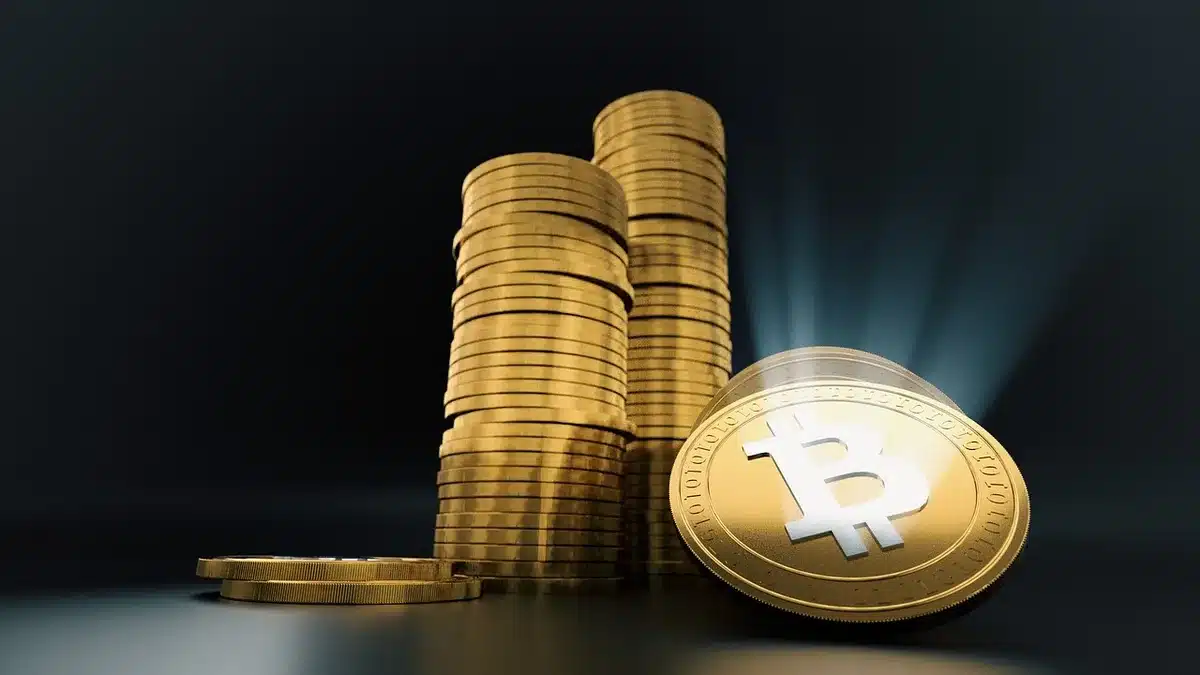 Bureau avec écrans montrant cours des crypto-actifs dans un espace de travail