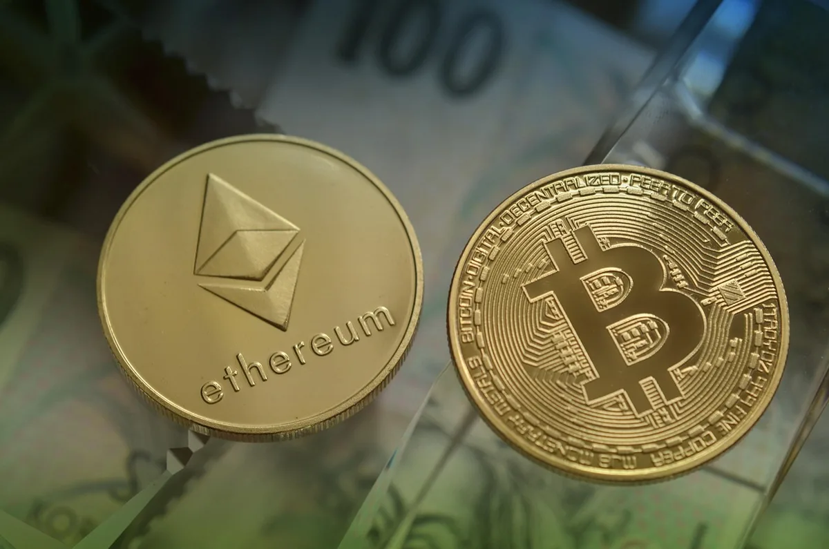 Graphique de cours crypto en baisse et pièces numériques sur un bureau éclairé