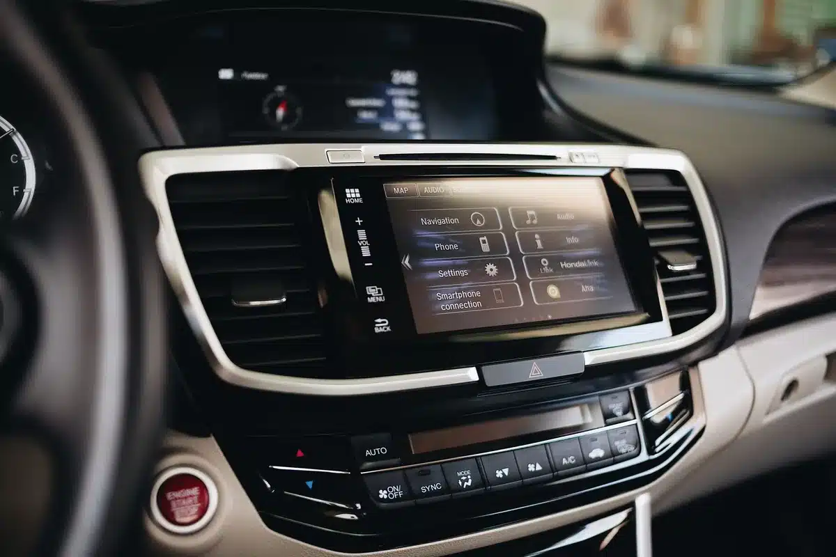 Empty car interior with a glowing unbranded infotainment screen showing a 3D map view, no people visible