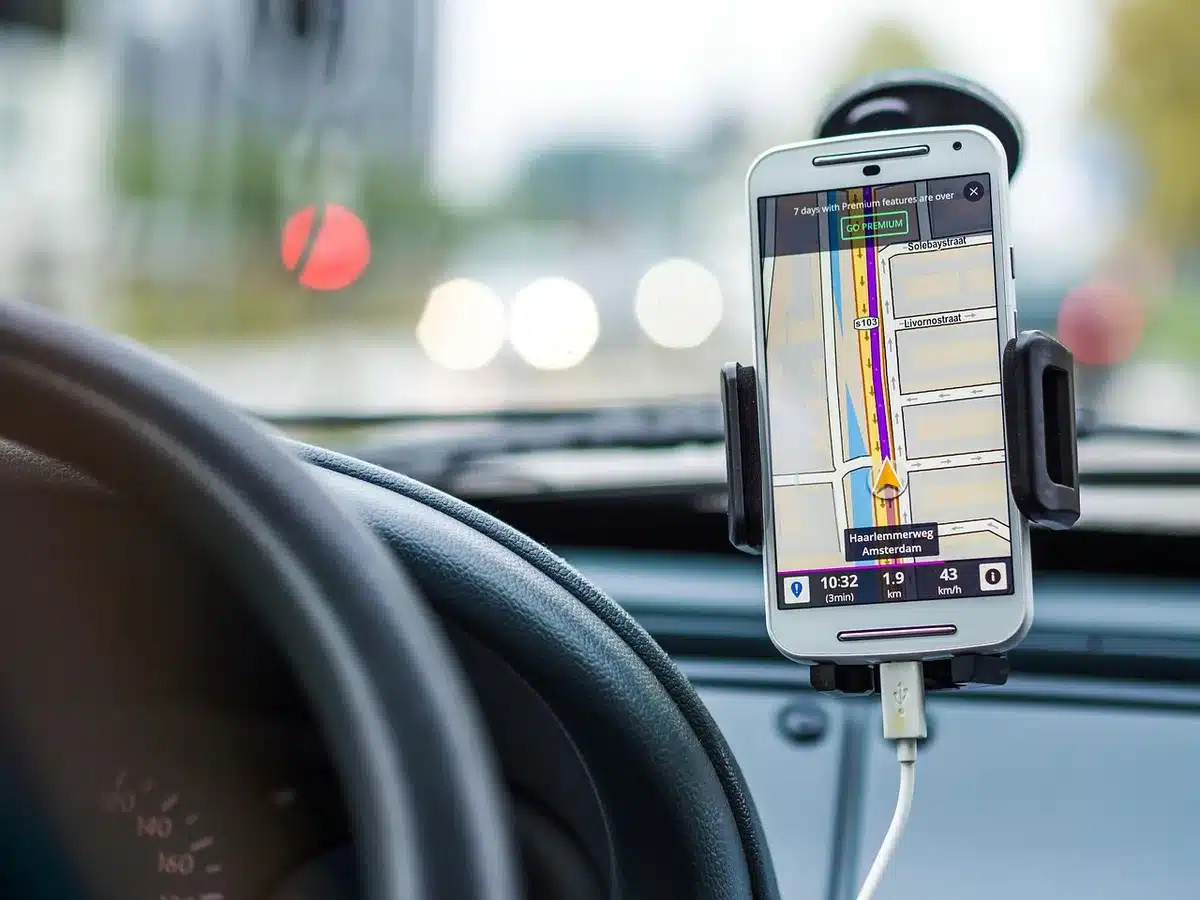 Anonymous close-up of a steering wheel and dashboard with a navigation route on screen, blurred background, no logos