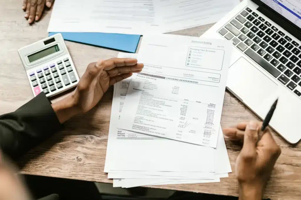 IA: peur ou assistant, les techs vendent avant tout un produit Table de réunion en plein jour avec documents et ordinateur portable