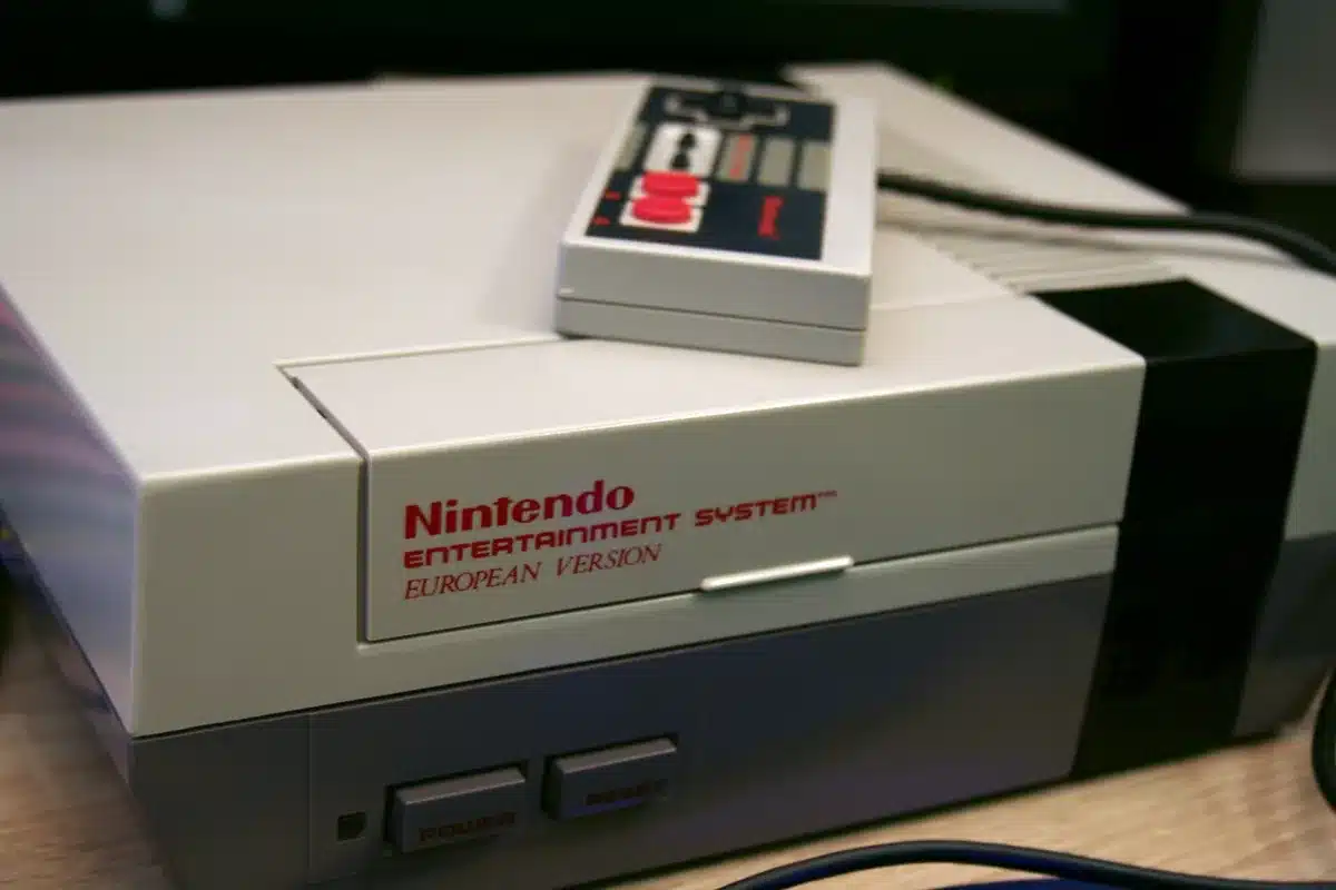 Gros plan sur une manette de jeu et un écran flou suggérant une scène réaliste