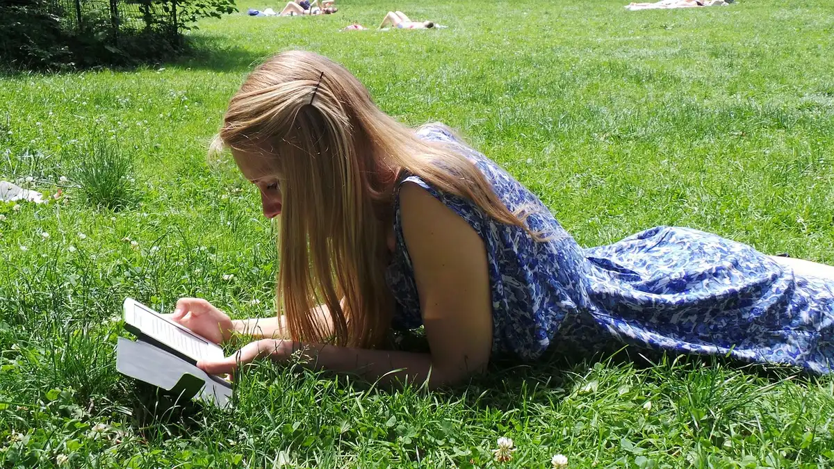 Liseuse Kindle posée sur une table près d'une tasse, lumière du jour