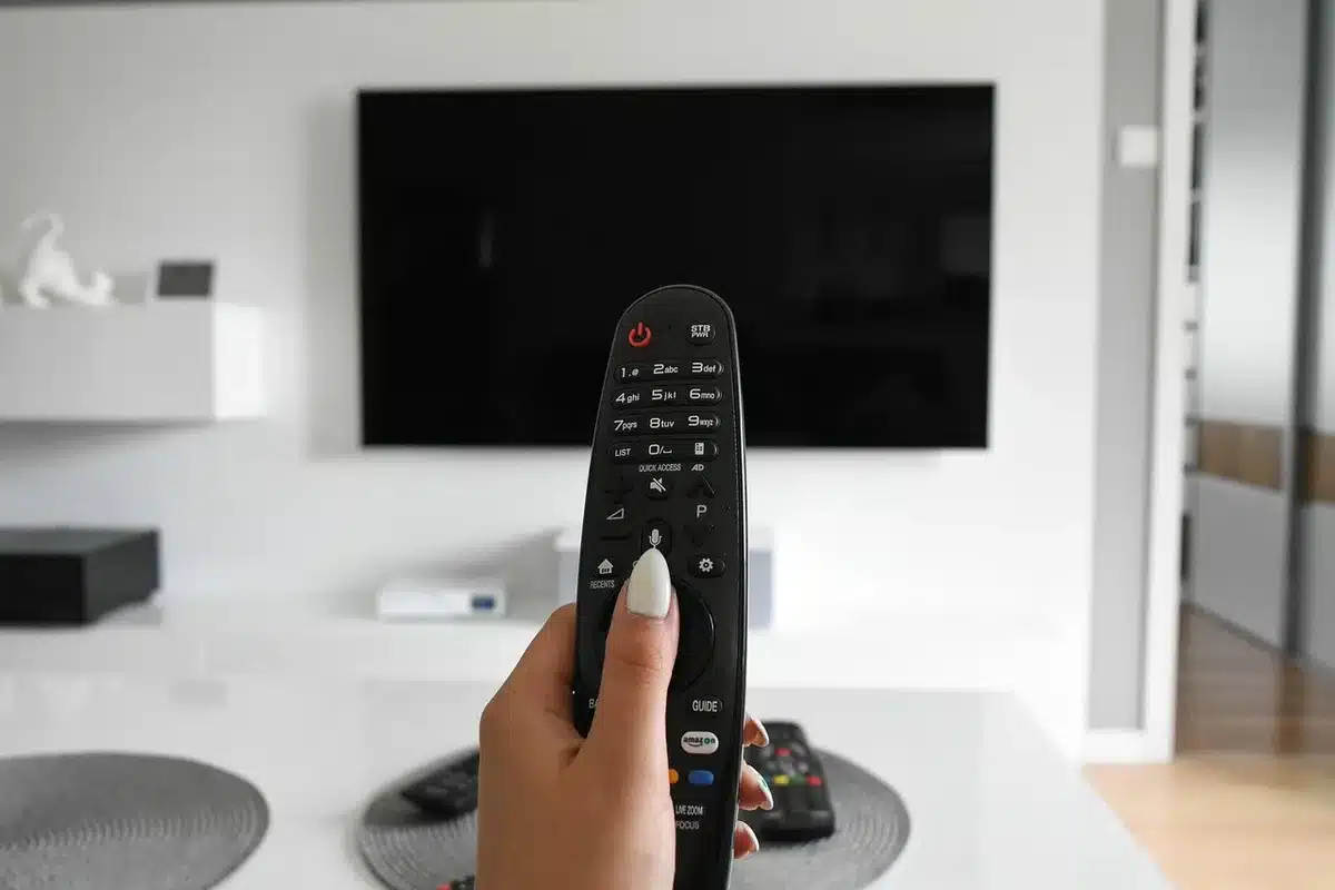Personne redémarrant une box TV avec une télécommande