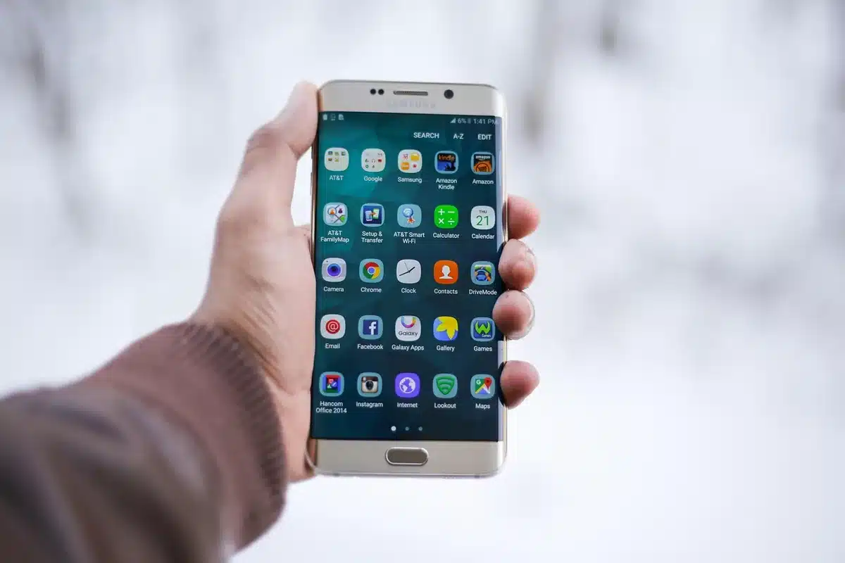 Personne anonyme comparant deux téléphones sur une table