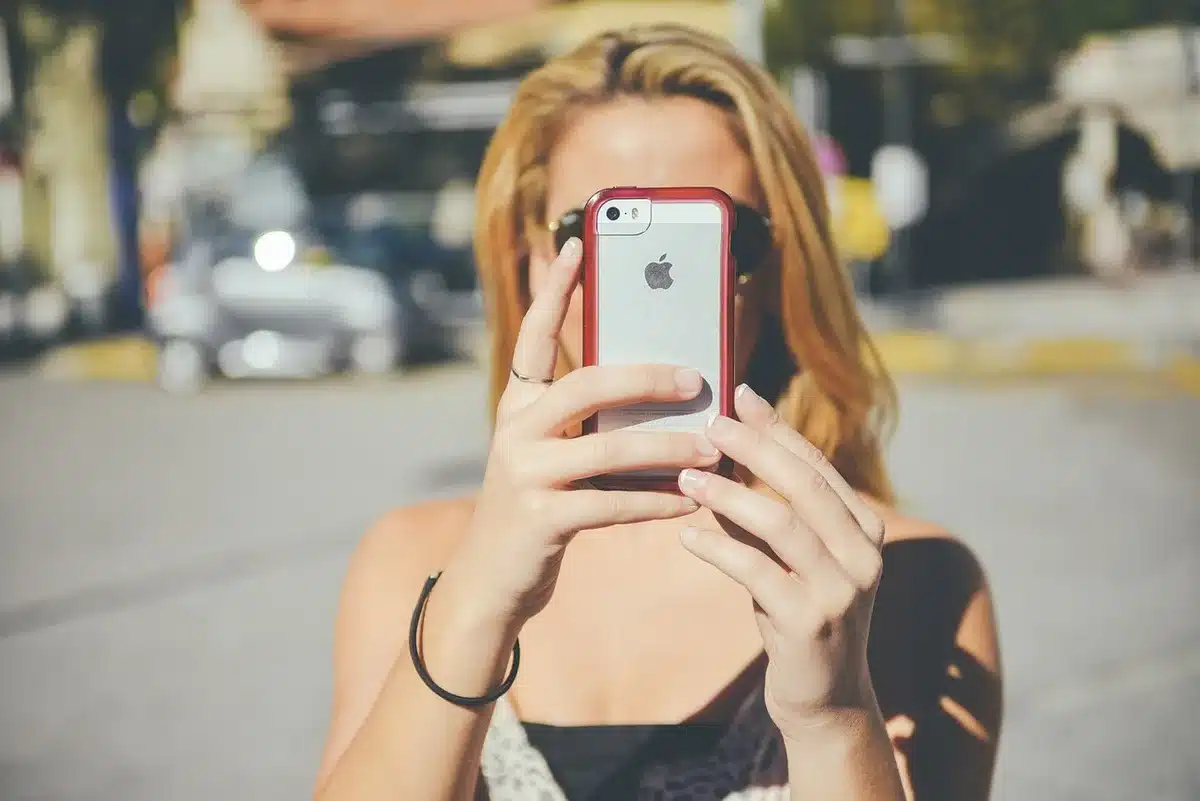 Personne utilisant l'application de calibration sur un smartphone face à la télévision